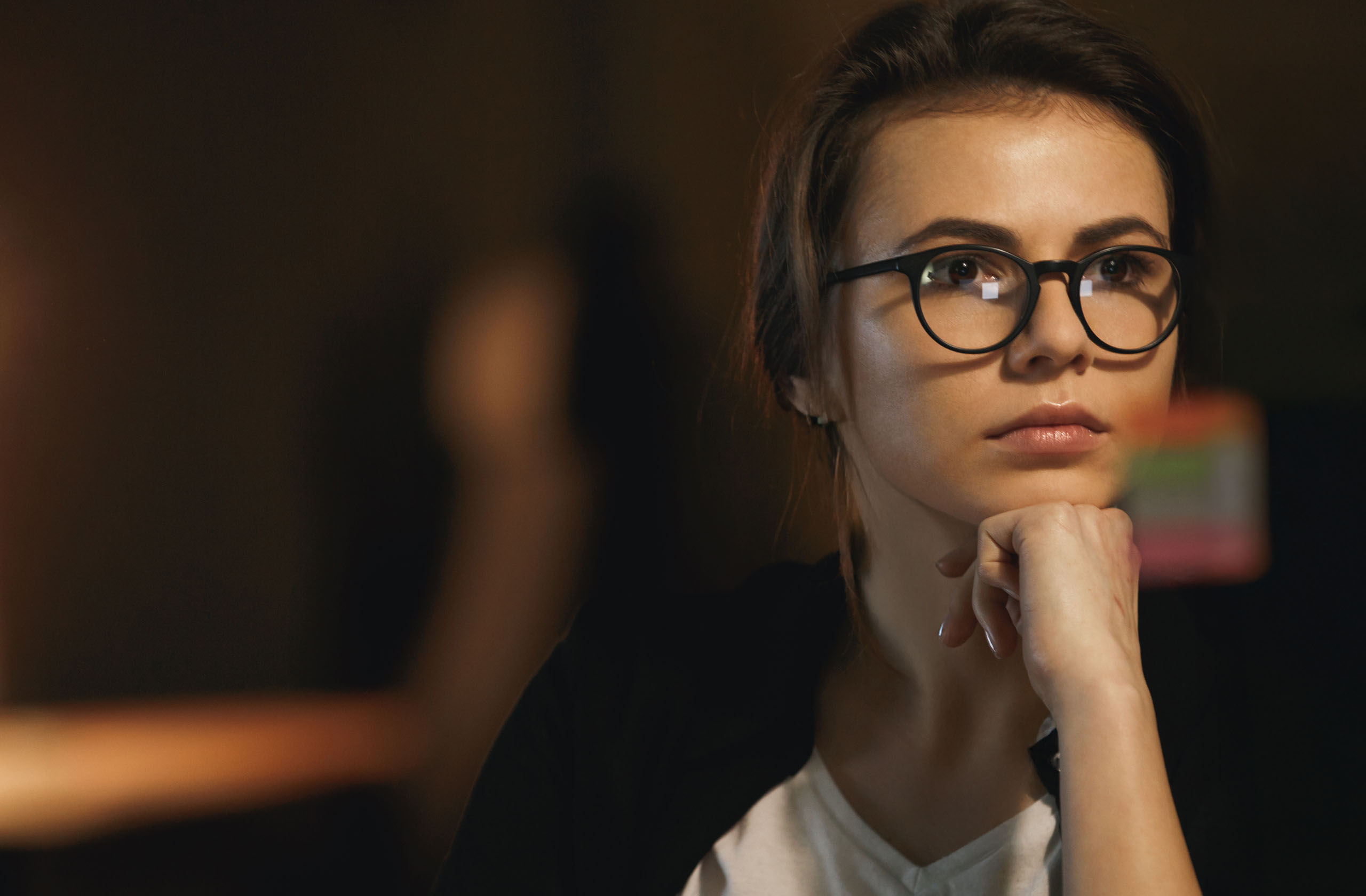 Persona en un entorno de trabajo moderno en momento de reflexión frente a una computadora, con iluminación suave y atmósfera de decisión, representando la tensión entre el avance de la inteligencia artificial y el control humano en contextos empresariales.